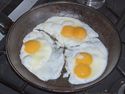Картинка към Жена пържи яйца за закуска